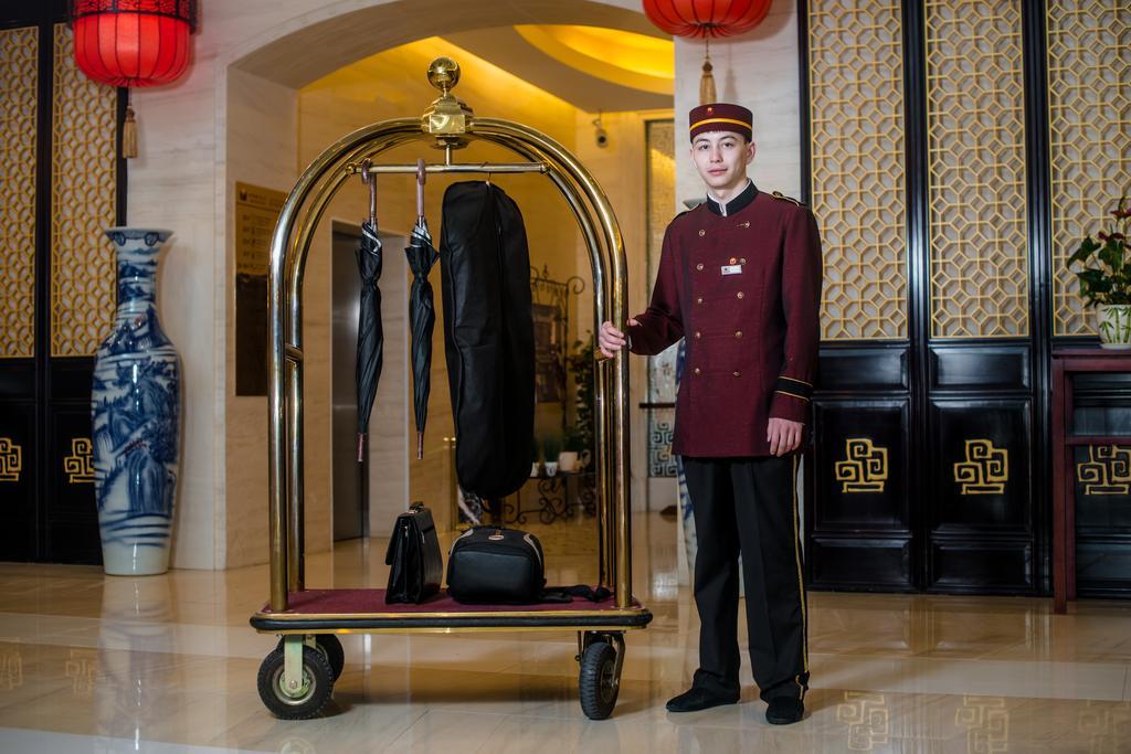 Beijing Palace Soluxe Hotel Astana Exterior photo A bellboy with a luggage cart